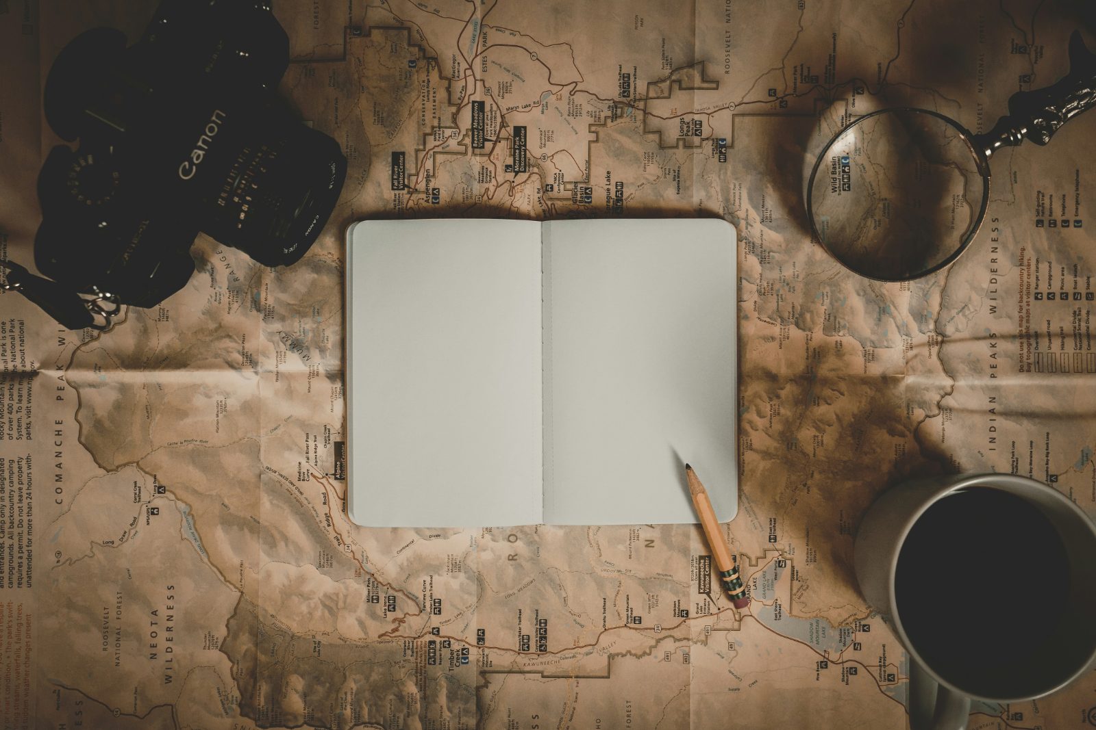Coffee, a camera, and an empty page in a notebook, ready to take down your journey